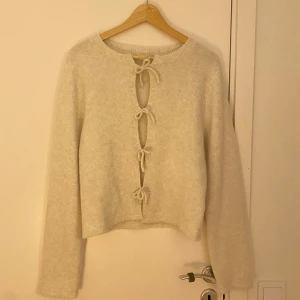 fin kofta med rosetter! 🌟 - Säljer denna beige-vita koftan! den är ifrån Kappahl. Rosseterna går inte att knyta upp. 