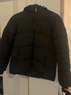 Svart pufferjacka med huva - Kappahl