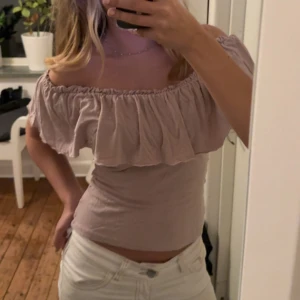 Rosa offshoulder volangtop - Säljer en rosa offshoulder topp med bred volang runt hela axelpartiet. Toppen är tight och har en croppad passform som framhäver midjan. Perfekt för dig som gillar romantiska och trendiga detaljer. Materialet känns mjukt och lätt mot huden. Säljer pga jag inte använder den längre 💕💕