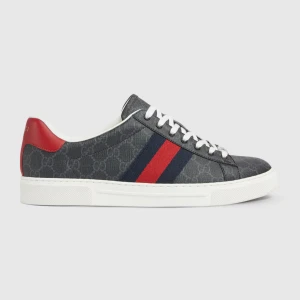 Gucci sneakers med GG-mönster - Snygga sneakers från Gucci i mörkgrått med GG-monogram över hela skon. Skorna har vita snören, röd och marinblå rand på sidan samt röd häl. Yttermaterialet är canvas med detaljer i skinn och en vit platt sula. Perfekta för dig som vill sticka ut med lyxig streetstyle.