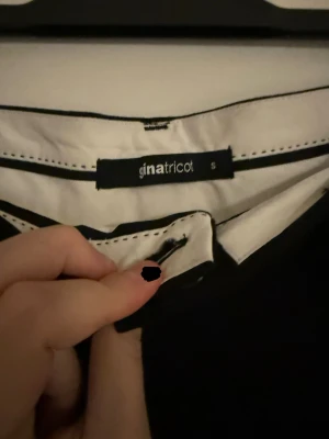 Svarta wide kostymbyxor Gina Tricot - Snygga svarta kostymbyxor från Gina Tricot i storlek S. Byxorna har en wide passform med raka, vida ben och klassisk midja. Perfekta för en clean och stilren look. Materialet är mjukt och känns bekvämt mot huden.