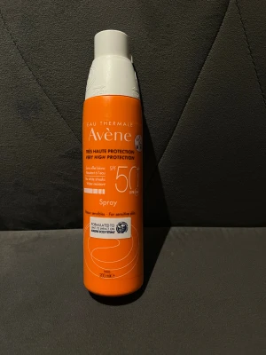 Avène Face Mist SPF 50+ - Avène Eau Thermale Face Mist SPF 50+ i en orange och vit sprayflaska på 200 ml. Ger hög solskyddsfaktor och är vattenresistent, passar känslig hud. Formulan är lätt och lämnar inga vita ränder. Perfekt att spraya över ansiktet för extra skydd mot UV-strålar.