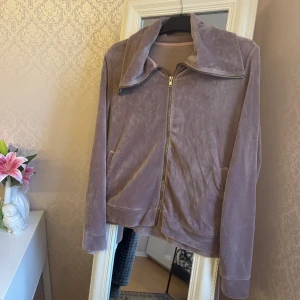Ljuslila velourjacka - Mjuk och chill ljuslila velourjacka med bred krage och hel dragkedja framtill. Jackan har två fickor på sidorna och långa ärmar. Vet inte vart den är köpt ifrån, men endast använd ett par gånger. I storlek L men passar perfekt på mig som har S/M i storlek 🥰