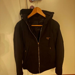Windbreaker Prqda  - Svart vindjacka från Prqda med huva och dragkedja framtill. Perfekt för kalla & blåsiga dagar och riktigt snygg streetstil. Storlek L passar även M.