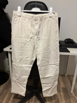 Linnebyxor  - Säljer ett par vita linnebyxor från H&M i storlek L. Byxorna har regular fit, används ej därav till salu! Pm vid fler frågor! 
