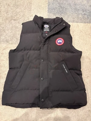 Canada goose väst  - Väldigt bra skick, har endast en skada vid dragkedjan men den fungerar fortfarande helt normalt och går att knäppa. Storlek L/G men sitter som xs-s