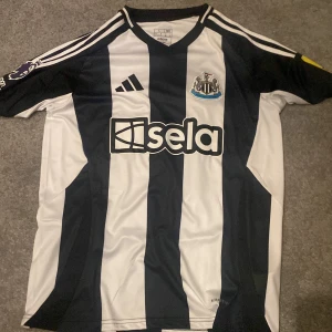 Newacastle united tröja 23/24 - Newcastle United fotbollströja med Premier League-logga och ISAK 14 på ryggen. Helt oanvänd och Storlek L. Hör av er vid frågor ✅