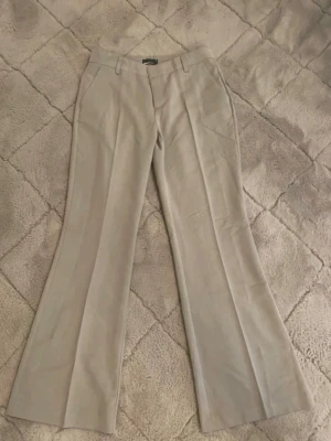 Beige bootcut kostymbyxor Gina Tricot - Snygga beige kostymbyxor från Gina Tricot i bootcut-modell.💕 Byxorna har aldrig används och säljs då jag beställde fel storlek!  Skriv privat vid intresse!🥰