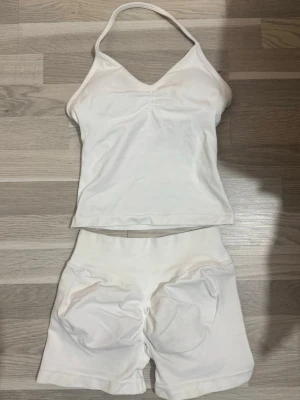 Dfyne set  - Bilderna visar ett vitt träningsset med topp och shorts från DFYNE, Setet är gjort i stretchigt material och har ribbade detaljer.