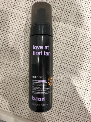 b.tan love at first tan mousse - Säljer en b.tan 'love at first tan' brun utan sol-mousse med violet base för en mörkare ton. Flaskan är svart med lila text och rymmer 200 ml. Moussen är vegansk och innehåller 100% naturlig DHA. Perfekt för dig som vill ha en djupare solbrun färg utan orangea toner.