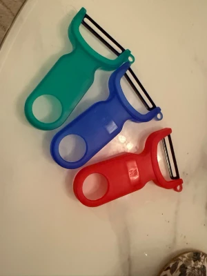 Köksskalare  - Säljer tre helt nya köksskalare i fina färger: grön, blå och röd. Skalarna har svart blad och är oanvända. Perfekta till köket eller som extra skalare hemma.