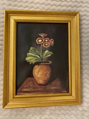 Tavlan  - En tavla med blommotiv i guldfärgad ram.