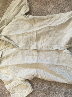 Beige relaxed skjorta från SMOG - Säljer en beige skjorta från SMOG i relaxed fit, storlek S. Skjortan har korta ärmar, knappar framtill och är gjord i ett mjukt bomullstyg med lite struktur. Perfekt för chill dagar och enkel att matcha med jeans eller shorts.