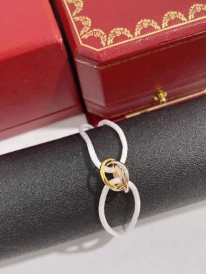 Trinity Armband - Ett armband med vita band och ringar i guld, silver och roséguld. Trinity armband