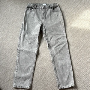 Grunt - Grå jeans - Snygga grå juniorjeans från Grunt med klassisk femficksdesign och raka ben. Byxorna har normal passform. Perfekta för dig som gillar en stilren och avslappnad look.