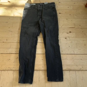 Jack & Jones Loose/Chris svarta jeans - Säljer ett par svarta jeans från Jack & Jones, modell Loose/Chris. Jeansen har en loose fit med raka ben och klassisk femficksdesign. Tillverkade i denim med snygg tvättad finish och detaljerade bakfickor. Perfekta för en avslappnad och trendig look. W28 L30