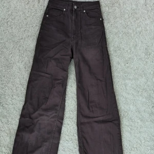 Bruna vida jeans med hög midja - Snygga bruna jeans med hög midja och raka, vida ben. Klassisk femficksmodell med bälteshällor och knappgylf. Från H&M i storlek 34 använda någon enstaka gång.