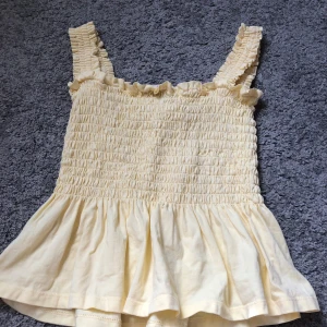 Gul Topp - Jag säljer en fin Gul Topp från Nelly, den är i nytt skick och aldrig använts jag har bara tvättat den en gång därav ser den lite skrynklig ut.  