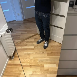 Nudie Lean Dean Selvedge Jeans - Säljer ett par mörkblå Selvedge jeans från Nudie Jeans i klassisk denim med orangea sömmar. Modellen har smal passform och normal midja, perfekta för dig som gillar en clean och stilren look. Jeansen börjar få en nice fade men använder man de mycket kommer de få en väldigt bra tvätt😇😇😇