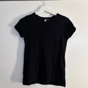 Svart basic t-shirt från H&M - En svart, enkel t-shirt från H&M med rund hals och korta ärmar. 