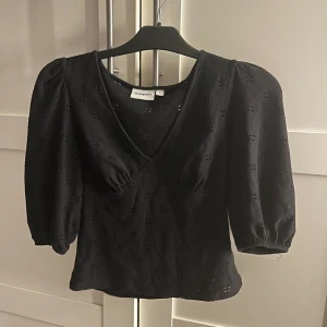 Svart blus med puffärm från Kappahl - Svart blus från Kappahl med v-ringning och trekvarts puffärmar. Använd 1 gång.