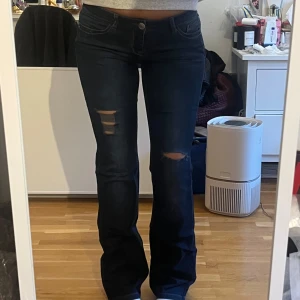 lågmidjade bootcut jeans  - Jättesnygga mörkblåa lågmidjade bootcut jeans med ’rips’🌟 från märket Bonobo. (Lite slitna längst ner, kan skicka en bild)