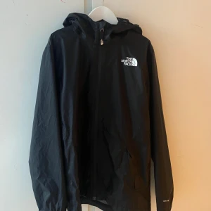 The north face vindjacka  - Säljer en svart snygg vindjacka från märket ”the north face.”Jag har köpt jackan begagnad innan men den är i gott skick och väl omhändertagen. Storleken är L i junior vilket motsvarar XS ungefär skulle jag säga. Den passar perfekt till dig som söker för en tunn jacka nu till lite kallare och blåsiga höst tider. Hör av er vid minsta funderingar om storlek, skick, anledning till salu mm och tveka ej! Guds frid