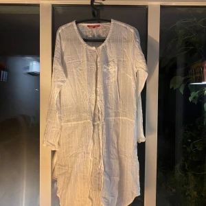 Vit långärmad skjortklänning Indiska - Luftig vit skjortklänning från Indiska i storlek L. Knappt använd därav säljes, nypris 699