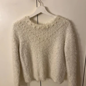 Stickad tröja - Stickad fluffig tröja, liten i storlek. Detaljerad med pärlor vid naken