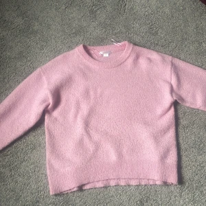 Ljusrosa stickad tröja Gina Tricot - Supermysig ljusrosa stickad tröja från Gina Tricot i storlek 158/164. Tröjan har rund halsringning, ribbade muddar och är långärmad. Perfekt för dig som gillar en enkel men söt look med en mjuk känsla.