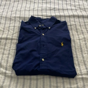 Ralph Lauren skjorta  - En jätte fin Ralph Lauren skjorta 👔 i mörkblå färg 🎨 med gult märke storlek S men kan passa M är använd 2 gånger pris kan diskuteras via intresse 👌