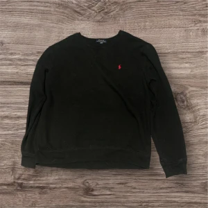 Svart tröja från Polo Ralph Lauren M - Svart långärmad tröja från Polo Ralph Lauren i storlek M. Klassisk rund halsringning och diskret röd logga broderad på bröstet. Nypris 1299kr