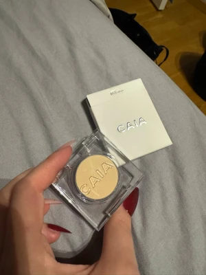 CAIA ögonskugga Mykonos - Säljer en CAIA ögonskugga i färgen Mykonos. Skuggan är ljusbeige med matt finish och kommer i en stilren transparent plastförpackning. Perfekt för att ljusa upp ögonlocket eller använda som bas. Förpackningen är liten och smidig att ta med.