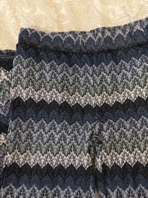 Mönstrade byxor  - Säljer ett par vida byxor med snyggt zigzag-mönster i olika färger. Byxorna är i ett stretchigt stickat material som känns både bekvämt och trendigt 🥰