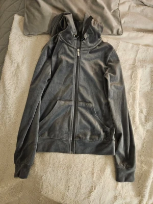 Mjuk och skön mörkgrå velourhoodie från Gina Tricot XXS - Jättefin och jättemjuk och skön mörkgrå hoodie från Gina Tricot i velourmaterial. Tröjan har huva med snörning, dragkedja framtill och två stora fickor. Långärmad och med breda muddar vid ärmslut och nederkant. Nyprid runt 200-300 kr. Säljer då jag inte får användning för den längre, men den är jättemjuk och skön att ha när det blir kallt. Mycket bra skick, endast använd väldigt få gånger. 💓