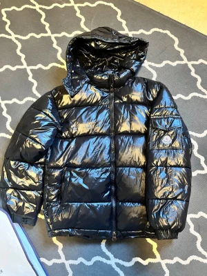 Moncler Maya - Moncler Maya med huva, Har orginal påsen. Oanvänd bara testad inomhus. Säljer pga har en annan jacka jag gillade mer. Jackan är perfekt för vintern och våren, väldigt varm och skön att bära. Slå en pling för mer bilder eller frågor!