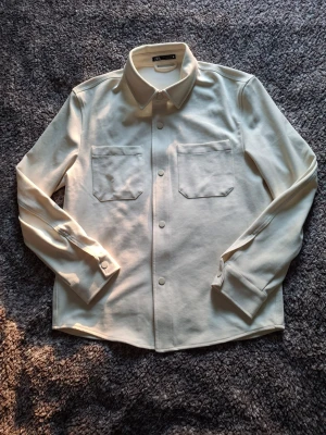 Zara overshirt - Beige overshirt från Zara 🤍 Stilren med tryckknappar och bröstfickor. Lite tunnare material – perfekt för vår/sommar 🌤️ I fint skick. Pris kan diskuteras 💬✨