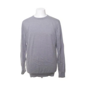 Grå tröja från John Henric - Säljer en stilren grå tröja från John Henric i 100% merinoull. Tröjan har en klassisk design med rund hals och långa ärmar, perfekt för kyligare dagar. Ett måste i garderoben för den som gillar kvalitet och komfort. Tröjan sitter mer som M