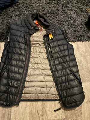 Svart dunväst från Parajumpers - Säljer min pjs väst äkta använd några gångenr har en liten skada där bak därför säljer jag den för mindre pris skickar ea7 koftan med också båda för en bra pris 