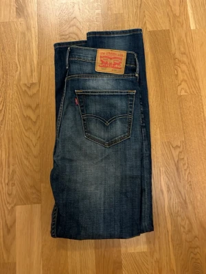 Levi's 522 blå jeans straight fit - Snygga Levi's 522 jeans i mörkblå tvätt med klassiska fem fickor och raka ben. Jeansen har en cool faded effekt framtill och bak, samt den ikoniska röda Levi's-taggen på bakfickan. Passar dig som gillar en enkel och tidlös stil.