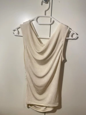 Draperad Topp - Créme vit draperad topp Köpt här på Vinted säljer då den inte passar mig så bra Lappen är bortklippt sen innan så vet inte var den är ifrån Skriv om du har några funderingar🫶🏼🫶🏼