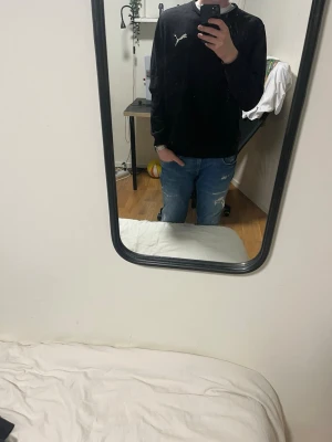 Svart långärmad tröja från Puma - Säljer en svart långärmad tröja från Puma med klassisk logga på bröstet. Tröjan har en enkel och stilren design, rund hals och normal passform. Perfekt för dig som gillar sportiga och avslappnade outfits.