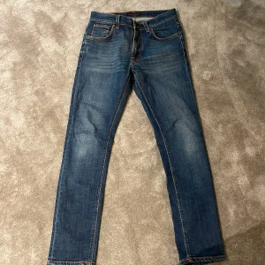 Blå jeans från Nudie Jeans - Snygga blå jeans från Nudie Jeans. Byxorna har raka ben och slim passform. Midjemått W29 och längd 30.