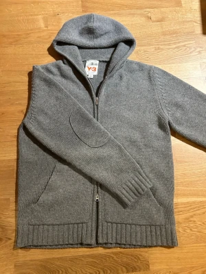 Yohji Yamamoto Y3 ull hoodie  - Yohji Yamamoto för Adidas Y3. Jätte sällsynt från A/W 2005 gjord i 100% ull och tillverkad i Italien. Hoodien har dubbel dragkedja och en Y3 loga på ryggen. Inte använd mycket alls och har inget tydligt slitage. Storlek L och kan skicka mått om nån behöver:)