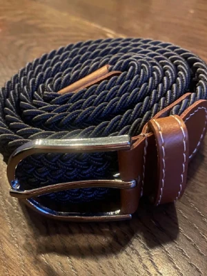 Flätat bälte/skärp grå  - Hej, säljer ett helt nytt & oanvändt bälte som är 105 cm lång och passar vem som helst! Den är grå/blå! Otroligt snygg 