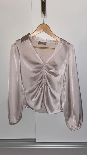 Ljusrosa/beige blus från Neo Noir, XS - Jättesöt blus från Neo Noir! Litet märke på baksidan på ena axeln men inget som syns om man har utsläppt hår.