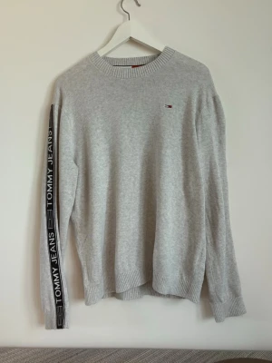 Grå stickad tröja Tommy Hilfiger - Snygg ljusgrå stickad tröja från Tommy Hilfiger. Oanvänd. Pris kan diskuteras, hör av dig vid minsta fråga!