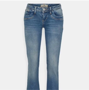 Blå bootcut jeans från LTB - Snygga blå bootcut jeans från LTB med klassisk femficksdesign och coola slitningar. Jeansen har kontrastsömmar och en unik broderad bakficka. Perfekta för dig som gillar en avslappnad men trendig look.