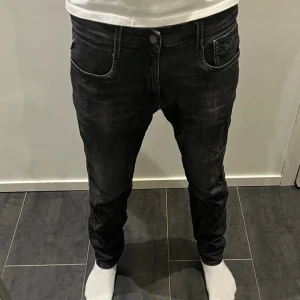 Replay Anbass jeans - Säljer ett par svarta Replay Anbass jeans som är tvärfeta strl w34 L32. Men passar w32/33. Jeansen har en jättesnygg passform och är tillverkade i stretchigt jeanstyg för extra komfort. Går aldrig ur stil, skriv gärna vid intresse!