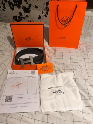Svart bälte med silver H spänne - Svart bälte med H spänne medföljer box, bag kvitto, H kort,